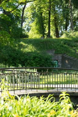 Riga 'daki parktaki kanal üzerinde güzel bir köprü. Letonya 'nın güneşli yaz manzarası, Kuzey Avrupa.