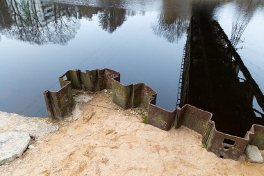 Nehrin üzerindeki eski metal demiryolu köprüsünün altında güzel bir bahar manzarası. Aşağıdan metal yapı.