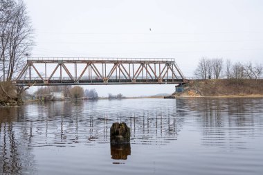 Nehrin üzerinde eski bir metal köprüsü olan güzel bir bahar manzarası. Riga, Latva 'da Doğal Bahar Manzarası.
