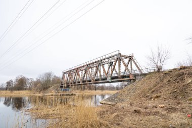 Nehrin üzerinde eski bir metal köprüsü olan güzel bir bahar manzarası. Riga, Latva 'da Doğal Bahar Manzarası.