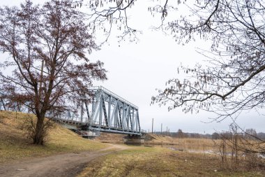 Nehrin üzerinde eski bir metal köprüsü olan güzel bir bahar manzarası. Riga, Latva 'da Doğal Bahar Manzarası.