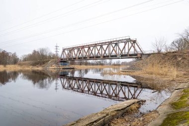 Nehrin üzerinde eski bir metal köprüsü olan güzel bir bahar manzarası. Riga, Latva 'da Doğal Bahar Manzarası.