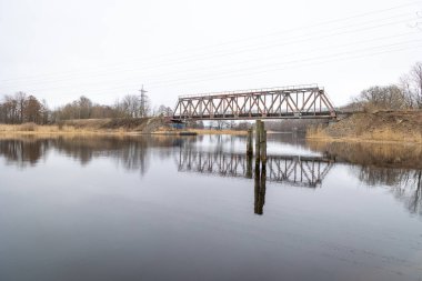 Nehrin üzerinde eski bir metal köprüsü olan güzel bir bahar manzarası. Riga, Latva 'da Doğal Bahar Manzarası.