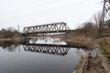 Nehrin üzerinde eski bir metal köprüsü olan güzel bir bahar manzarası. Riga, Latva 'da Doğal Bahar Manzarası.