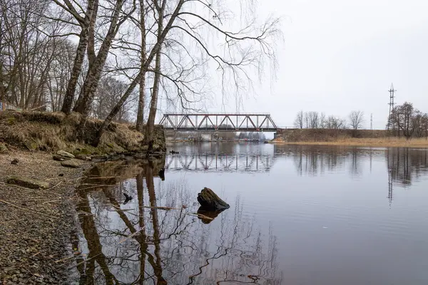 Nehrin üzerinde eski bir metal köprüsü olan güzel bir bahar manzarası. Riga, Latva 'da Doğal Bahar Manzarası.