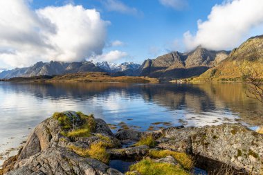 Norveç 'in Lofoten adalarındaki fiyortlarda güneşli bir sonbahar gününde güzel kayalık kıyı manzarası. İskandinavya 'nın mevsimlik manzarası.