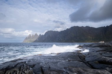 Okyanus dalgaları Norveç, Senja 'daki kayalık Tungeneset plajına çarpıyor. İskandinavya 'nın mevsimlik manzarası.