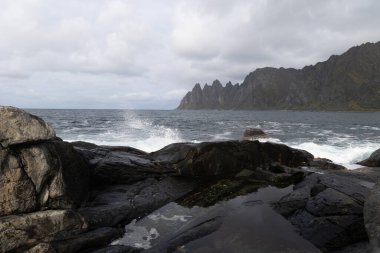 Okyanus dalgaları Norveç, Senja 'daki kayalık Tungeneset plajına çarpıyor. İskandinavya 'nın mevsimlik manzarası.