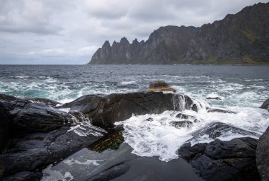 Okyanus dalgaları Norveç, Senja 'daki kayalık Tungeneset plajına çarpıyor. İskandinavya 'nın mevsimlik manzarası.