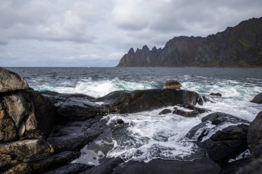 Okyanus dalgaları Norveç, Senja 'daki kayalık Tungeneset plajına çarpıyor. İskandinavya 'nın mevsimlik manzarası.