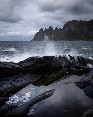 Okyanus dalgaları Norveç, Senja 'daki kayalık Tungeneset plajına çarpıyor. İskandinavya 'nın mevsimlik manzarası.