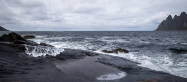 Ocean waves crushing on the rocky Tungeneset beach, Senja, Norway. Seasonal scenery of Scandinavia. clipart