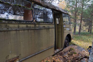 Kuzey Norveç ormanlarında terk edilmiş, terk edilmiş, paslı bir otobüs. Sihirli otobüs. İskandinavya 'nın mevsimlik manzarası.