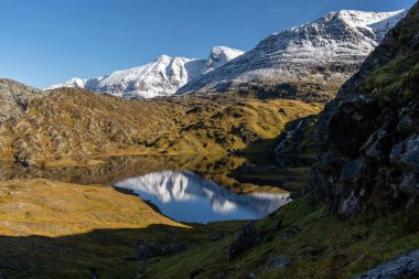 Kuzey Norveç 'te dağ gölü olan güzel bir sonbahar manzarası. İskandinavya 'nın mevsimlik manzarası.