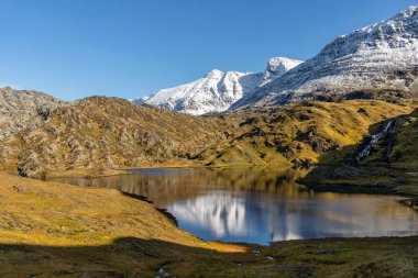 Kuzey Norveç 'te dağ gölü olan güzel bir sonbahar manzarası. İskandinavya 'nın mevsimlik manzarası.