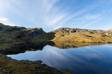 Kuzey Norveç 'te sonbaharda göl yüzeyindeki güzel dağ yansımaları. İskandinavya 'nın mevsimlik manzarası.