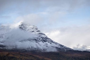 Kuzey Norveç 'te karlı dağ tepeleri olan güzel bir sonbahar manzarası. İskandinavya 'nın mevsimlik manzarası.