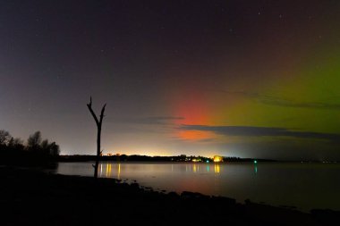 Letonya üzerinde sonbahar gökyüzünde güzel bir kuzey ışığı gösterisi. Aurora Borealis un Baltis Country gecesi. Kuzey Avrupa 'nın mevsimlik manzarası.