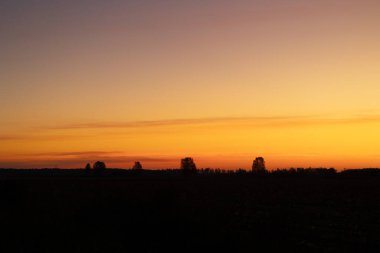 Letonya kırsalının üzerinde güzel renkli sonbahar gündoğumu gökyüzü. Kuzey Avrupa 'nın mevsimlik manzarası.