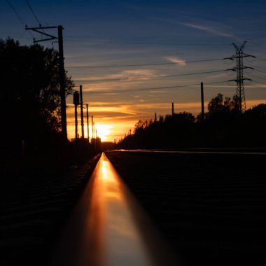 Riga, Letonya 'da demiryolu raylarında güzel bir sonbahar günbatımı. Kuzey Avrupa 'nın mevsimlik manzarası.