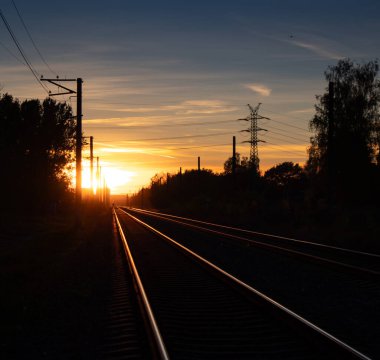 Riga, Letonya 'da demiryolu raylarında güzel bir sonbahar günbatımı. Kuzey Avrupa 'nın mevsimlik manzarası.
