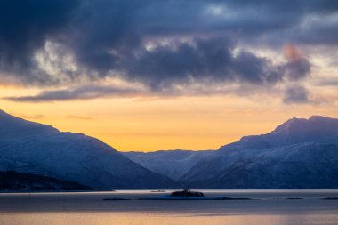 Karlı kış günlerinde Norveç fiyortlarında güzel küçük bir ada. Kış mevsiminde İskandinavya 'da Kuzey Kutbu doğası.