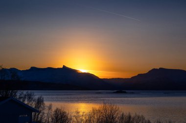 Karlı kış günlerinde Norveç fiyortlarında güzel küçük bir ada. Kış mevsiminde İskandinavya 'da Kuzey Kutbu doğası.
