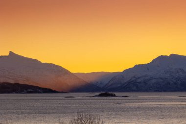 Karlı kış günlerinde Norveç fiyortlarında güzel küçük bir ada. Kış mevsiminde İskandinavya 'da Kuzey Kutbu doğası.