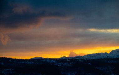 Güzel, renkli kış gündoğumu gökyüzü Norveç 'teki karlı dağların ve fiyortların üzerinde kutup gecesi boyunca. Kış mevsiminde İskandinavya 'da Kuzey Kutbu doğası.