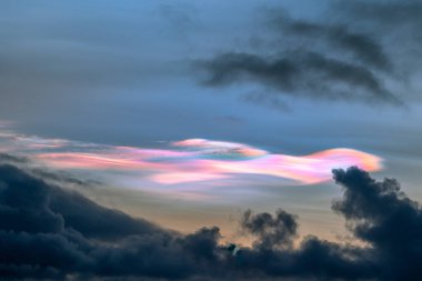 Norveç 'te kışın gökyüzünde nadir görülen bir kutup stratosferik bulut görüntüsü. Gökyüzünde güneş ışınları içinde renkli buz kristalleri. Kış mevsiminde İskandinavya 'da Kuzey Kutbu doğası.