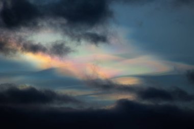 Norveç 'te kışın gökyüzünde nadir görülen bir kutup stratosferik bulut görüntüsü. Gökyüzünde güneş ışınları içinde renkli buz kristalleri. Kış mevsiminde İskandinavya 'da Kuzey Kutbu doğası.