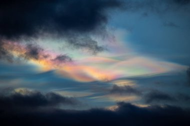 Norveç 'te kışın gökyüzünde nadir görülen bir kutup stratosferik bulut görüntüsü. Gökyüzünde güneş ışınları içinde renkli buz kristalleri. Kış mevsiminde İskandinavya 'da Kuzey Kutbu doğası.