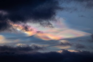 Norveç 'te kışın gökyüzünde nadir görülen bir kutup stratosferik bulut görüntüsü. Gökyüzünde güneş ışınları içinde renkli buz kristalleri. Kış mevsiminde İskandinavya 'da Kuzey Kutbu doğası.
