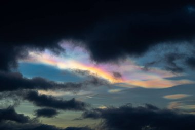 Norveç 'te kışın gökyüzünde nadir görülen bir kutup stratosferik bulut görüntüsü. Gökyüzünde güneş ışınları içinde renkli buz kristalleri. Kış mevsiminde İskandinavya 'da Kuzey Kutbu doğası.