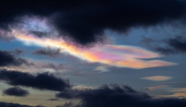 Norveç 'te kışın gökyüzünde nadir görülen bir kutup stratosferik bulut görüntüsü. Gökyüzünde güneş ışınları içinde renkli buz kristalleri. Kış mevsiminde İskandinavya 'da Kuzey Kutbu doğası.