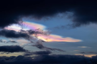 Norveç 'te kışın gökyüzünde nadir görülen bir kutup stratosferik bulut görüntüsü. Gökyüzünde güneş ışınları içinde renkli buz kristalleri. Kış mevsiminde İskandinavya 'da Kuzey Kutbu doğası.
