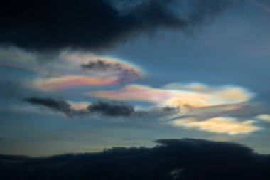 Norveç 'te kışın gökyüzünde nadir görülen bir kutup stratosferik bulut görüntüsü. Gökyüzünde güneş ışınları içinde renkli buz kristalleri. Kış mevsiminde İskandinavya 'da Kuzey Kutbu doğası.