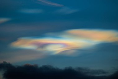 Norveç 'te kışın gökyüzünde nadir görülen bir kutup stratosferik bulut görüntüsü. Gökyüzünde güneş ışınları içinde renkli buz kristalleri. Kış mevsiminde İskandinavya 'da Kuzey Kutbu doğası.