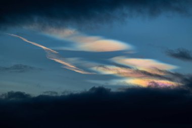 Norveç 'te kışın gökyüzünde nadir görülen bir kutup stratosferik bulut görüntüsü. Gökyüzünde güneş ışınları içinde renkli buz kristalleri. Kış mevsiminde İskandinavya 'da Kuzey Kutbu doğası.