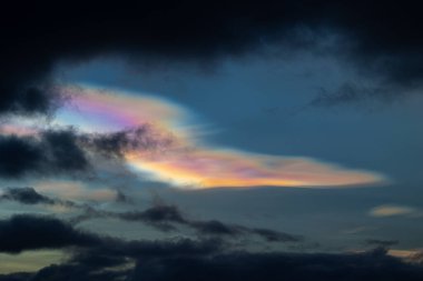 Norveç 'te kışın gökyüzünde nadir görülen bir kutup stratosferik bulut görüntüsü. Gökyüzünde güneş ışınları içinde renkli buz kristalleri. Kış mevsiminde İskandinavya 'da Kuzey Kutbu doğası.
