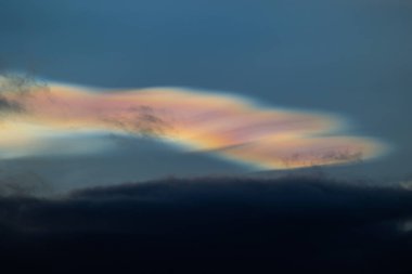 Norveç 'te kışın gökyüzünde nadir görülen bir kutup stratosferik bulut görüntüsü. Gökyüzünde güneş ışınları içinde renkli buz kristalleri. Kış mevsiminde İskandinavya 'da Kuzey Kutbu doğası.