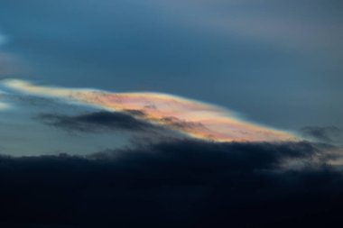 Norveç 'te kışın gökyüzünde nadir görülen bir kutup stratosferik bulut görüntüsü. Gökyüzünde güneş ışınları içinde renkli buz kristalleri. Kış mevsiminde İskandinavya 'da Kuzey Kutbu doğası.