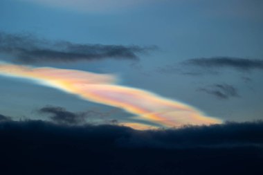 Norveç 'te kışın gökyüzünde nadir görülen bir kutup stratosferik bulut görüntüsü. Gökyüzünde güneş ışınları içinde renkli buz kristalleri. Kış mevsiminde İskandinavya 'da Kuzey Kutbu doğası.