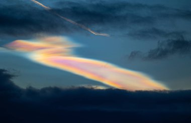 Norveç 'te kışın gökyüzünde nadir görülen bir kutup stratosferik bulut görüntüsü. Gökyüzünde güneş ışınları içinde renkli buz kristalleri. Kış mevsiminde İskandinavya 'da Kuzey Kutbu doğası.
