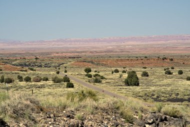 Asfalt karayolu Arizona 'nın çorak arazisine doğru ilerliyor.