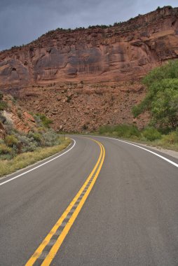 Arizona 'nın kırsal kesimindeki bir kanyonda asfalt karayolu bükülüyor.