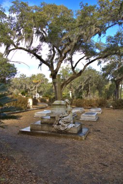 Savannah Tarihi Bonaventure Mezarlığı, Ön planda belirgin haç ile Ga. Serene sahne, yemyeşil bitki örtüsü, ve İspanyol yosun