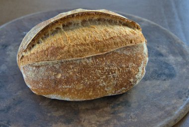 Artisan Sourdough Bread loaf on a pizza stone direct from the oven