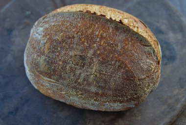 Artisan Sourdough Bread loaf on a pizza stone direct from the oven