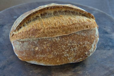 Artisan Sourdough Bread loaf on a pizza stone direct from the oven